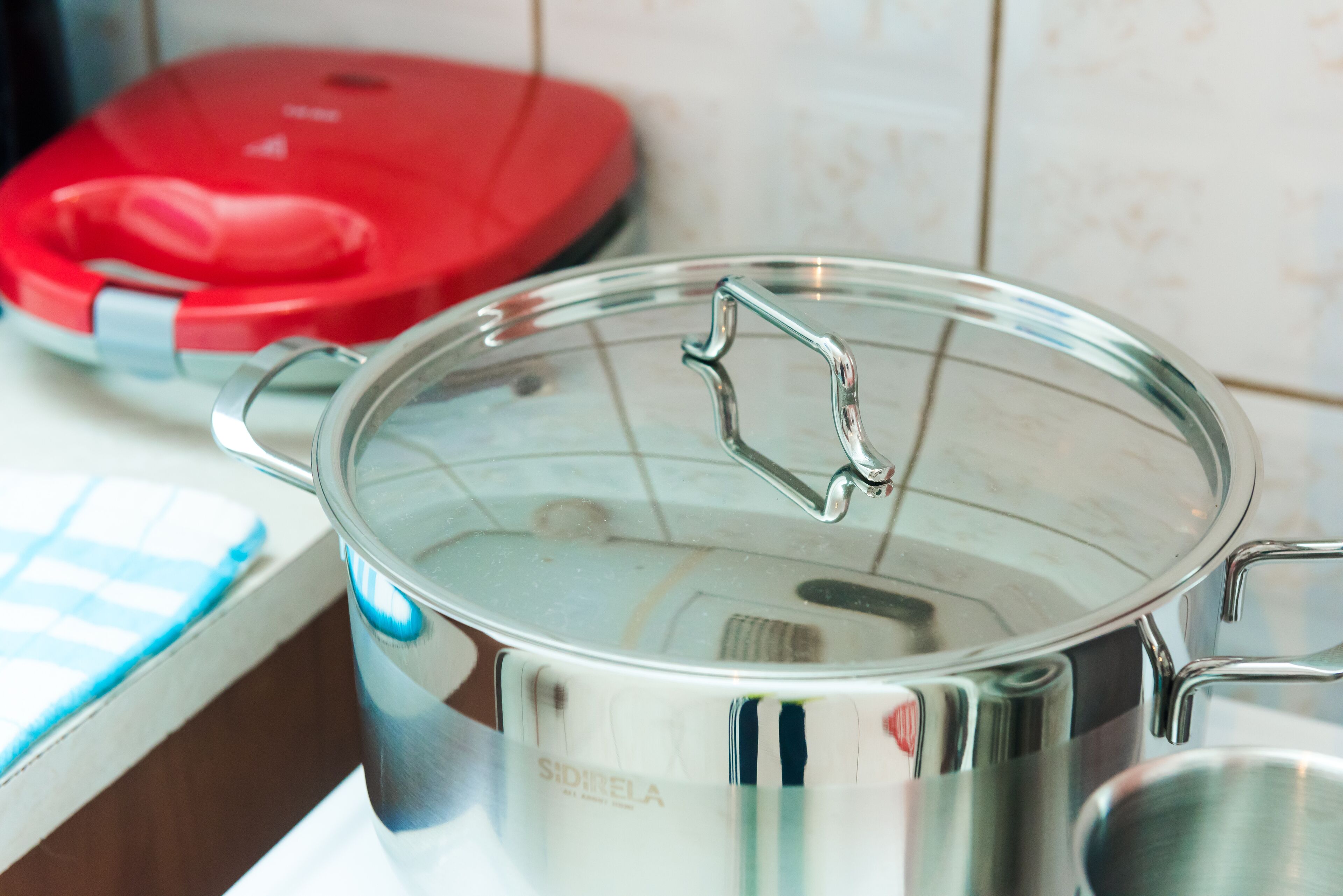 A stainless steel pot with a lid on a kitchen counter.
