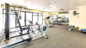 A gym with various exercise equipment, including treadmills and stationary bikes, arranged in a spacious layout. - Central Cute Studio with Kitchenette, Pool and Gym (Auckland CBD)