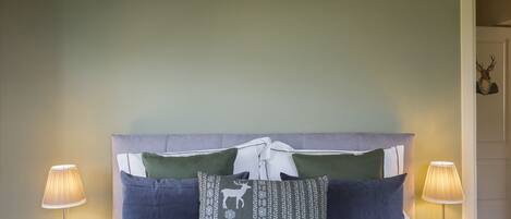 Un lit avec une tête de lit, deux lampes de chevet et des coussins décoratifs.