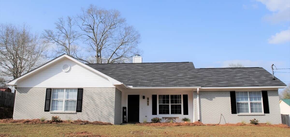 A single-story house with a gabled roof, a front porch, and a garage door.