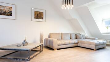 A modern living room with a sectional sofa, a coffee table, and two framed artworks on the wall.