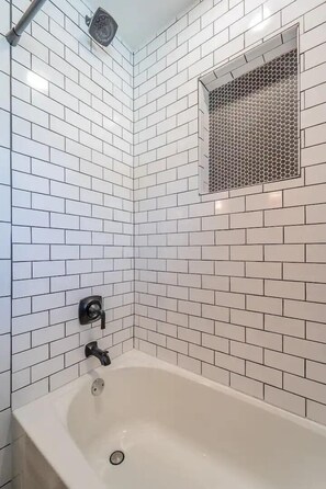 Bathtub, hair dryer, towels, shampoo
