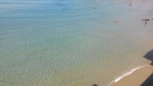 Une plage avec une eau claire et peu profonde et un rivage sablonneux.