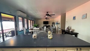 Una cocina con una isla grande, armarios de madera y un comedor con mesa y sillas.