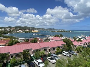 A coastal town with buildings having red roofs, a marina with boats, and a clear blue sky. - This Gorgeous Oceanview Condo is the Perfect Caribbean Retreat! (Christiansted)