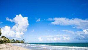 A beach with clear skies, palm trees, and ocean waves. - Beach Villages,  3 Bedrooms, Just Renovated (Humacao)