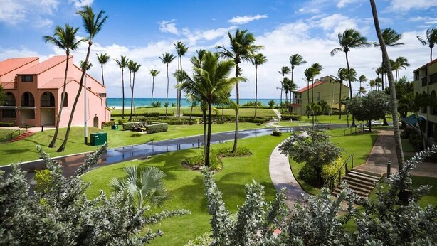 A resort with a pool, palm trees, and a view of the ocean. - Beach Villages,  3 Bedrooms, Just Renovated (Humacao)