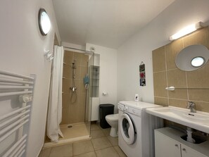 A modern bathroom with a shower, toilet, and washing machine. - App. T2 All comforts, swimming pool, terrace, wifi, 500 m beach, parking, washing machine. (Santa-Maria-Poggio)