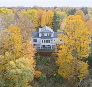A two-story house with a large porch, surrounded by autumn-colored trees. - 5BR Saugatuck-Area Home with Incredible Views (Douglas)