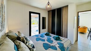 Une chambre moderne avec un lit, un canapé, une suspension et une vue sur l’extérieur.