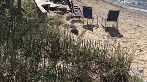 Ein Strand mit Liegestühlen und einer Holzterrasse.