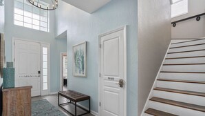 A hallway with a bench, a private door, a staircase, and a window with blinds. - Extrended Pool Deck/No Rear Neighbors/Windsor Hills Resort, 3 Miles to Disney®! (Kissimmee)