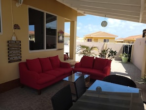 Relax in a serene outdoor seating area with a sofa, table, and wicker chair.