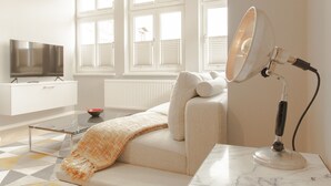 Een moderne woonkamer met een bank, een televisie en een lamp.