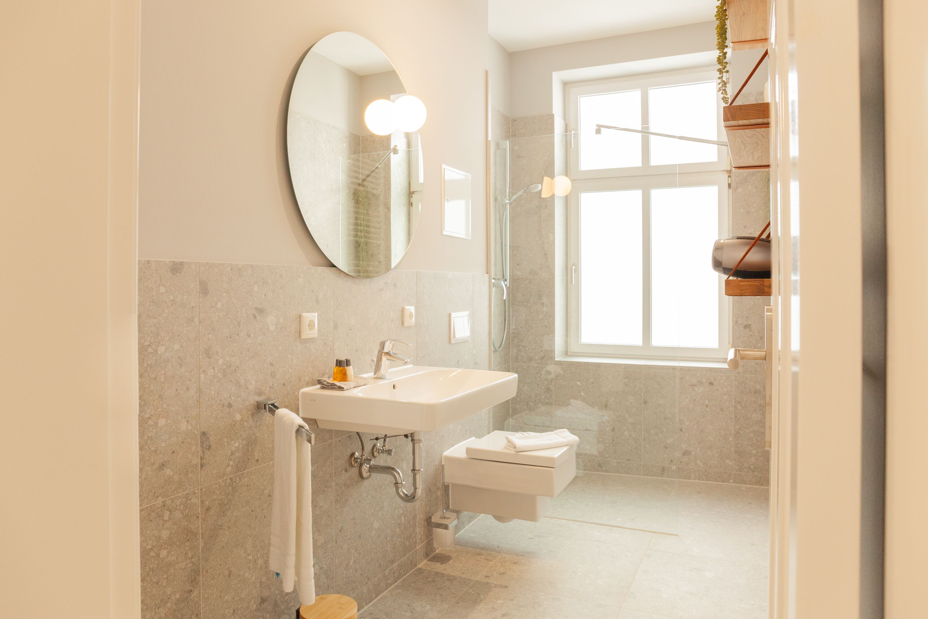 Un baño moderno con un espejo grande, un lavabo y una ducha.