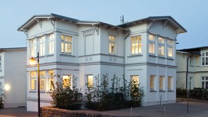 Een meerlaags gebouw in klassieke stijl, met symmetrische ramen en een stenen grondvloer.
