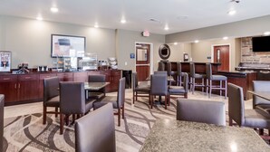 A hotel lobby with a reception desk, seating area, and a coffee station. - Cobblestone Inn & Suites-Fremont (Fremont)