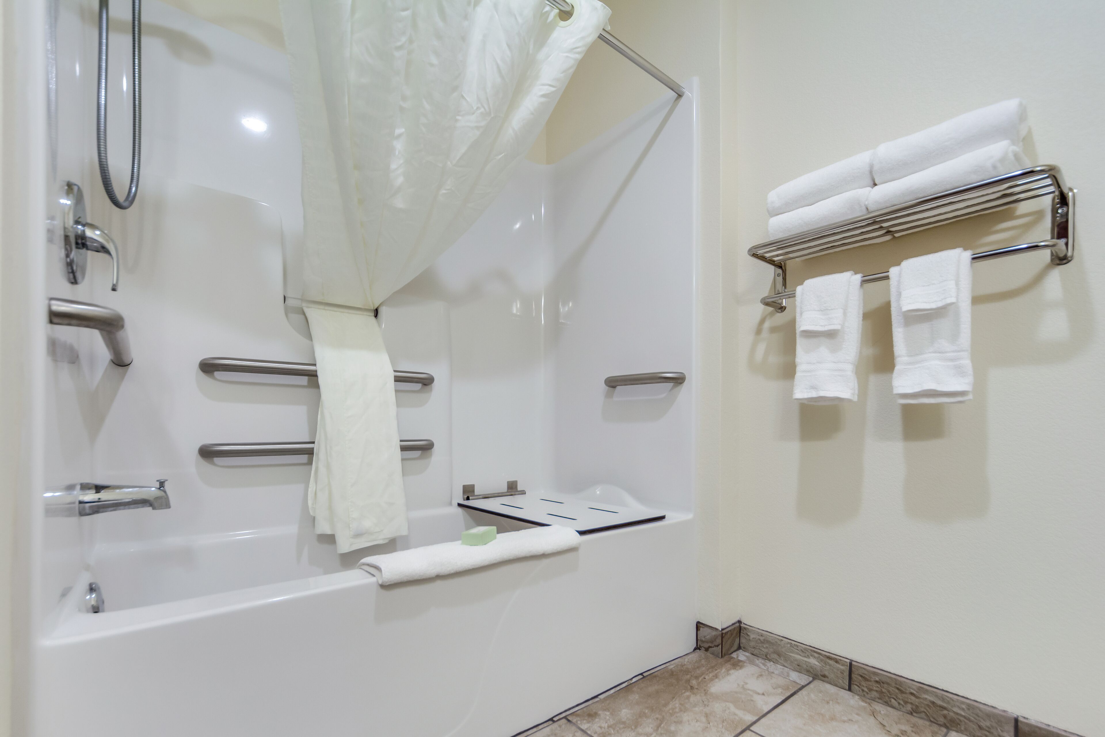 Une salle de bain moderne équipée d’une baignoire, d’une douche et d’un porte-serviettes.