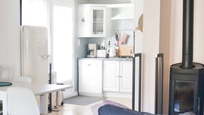 Una cocina moderna con armarios blancos, una estufa negra y un comedor con mesa y sillas.