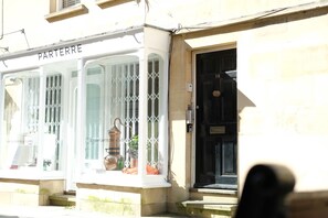 A building with a sign reading "PARTERRE" and a window displaying a perfume bottle.