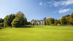 A golf course with a clubhouse in the background.
