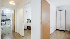 A modern apartment with a kitchen, a bedroom, and a wardrobe. - Impeccable 2-bed Apartment in Romford (Romford)