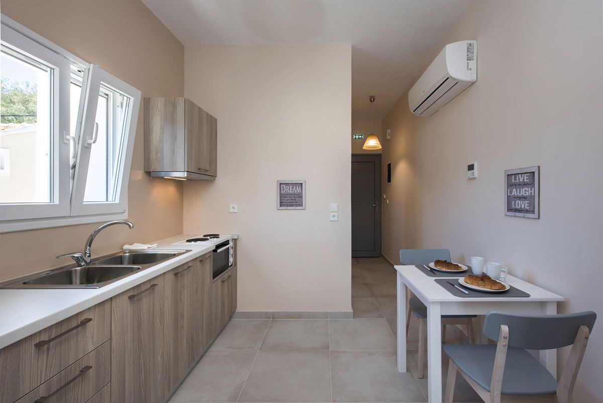 A compact kitchen with a window, a dining table with chairs, and a small dining area.