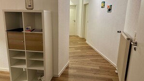 A hallway with a white storage unit and a radiator on the right.