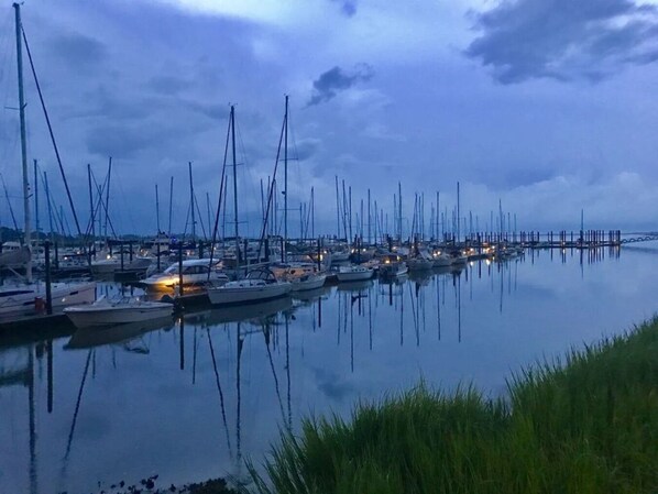 Un puerto deportivo con numerosos veleros amarrados durante la noche.