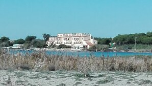 Ein großes, mehrgeschossiges Gebäude mit einer symmetrischen Fassade, in der Nähe von Wasser gelegen.