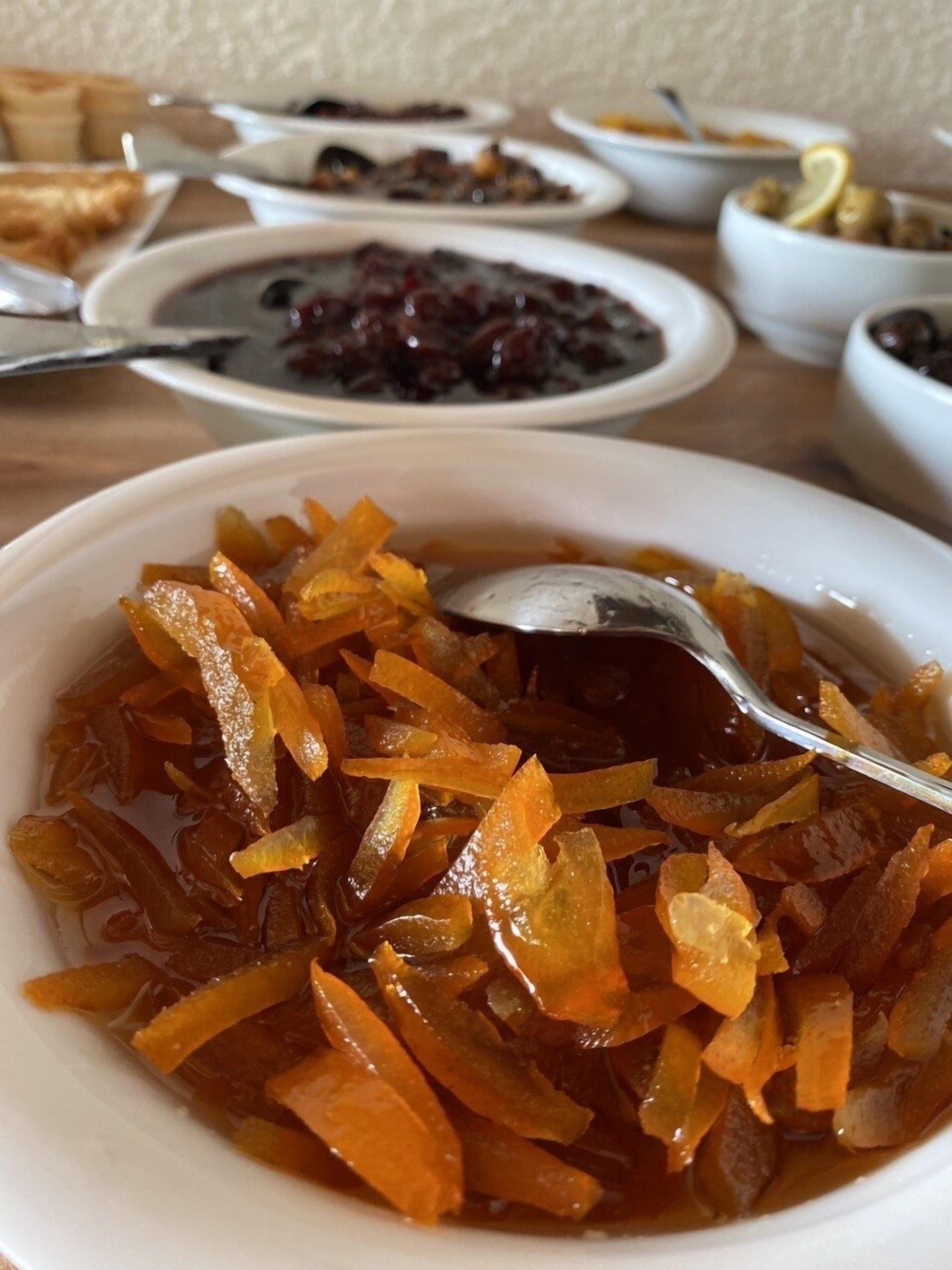 A table with various dishes, including a bowl of candied fruit and other food items.