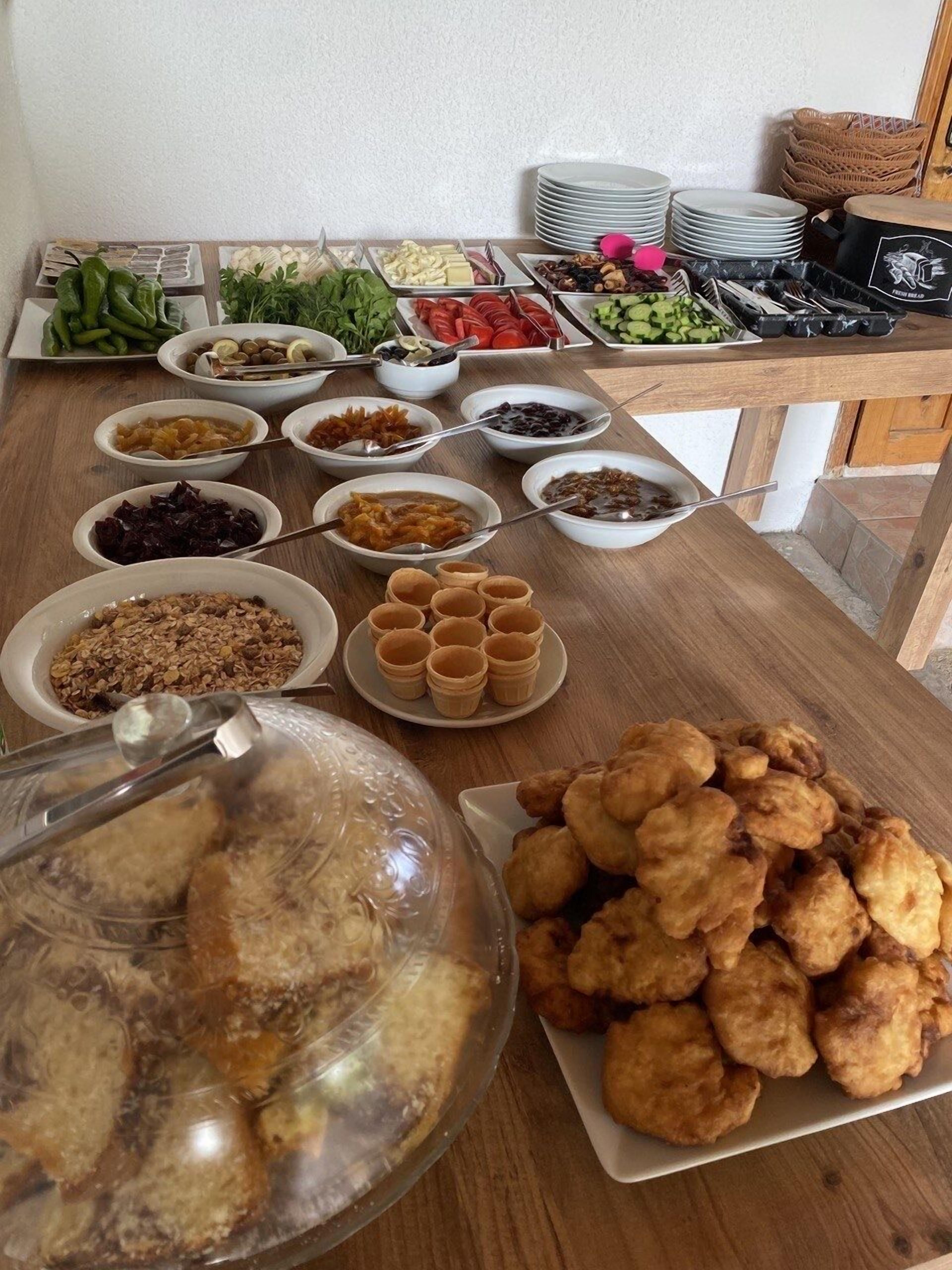 A buffet table with various dishes including salads, fruits, and baked goods.