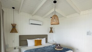 A hotel room with a wooden bed, white walls, and a ceiling fan. - Picuas Village (Río Grande)