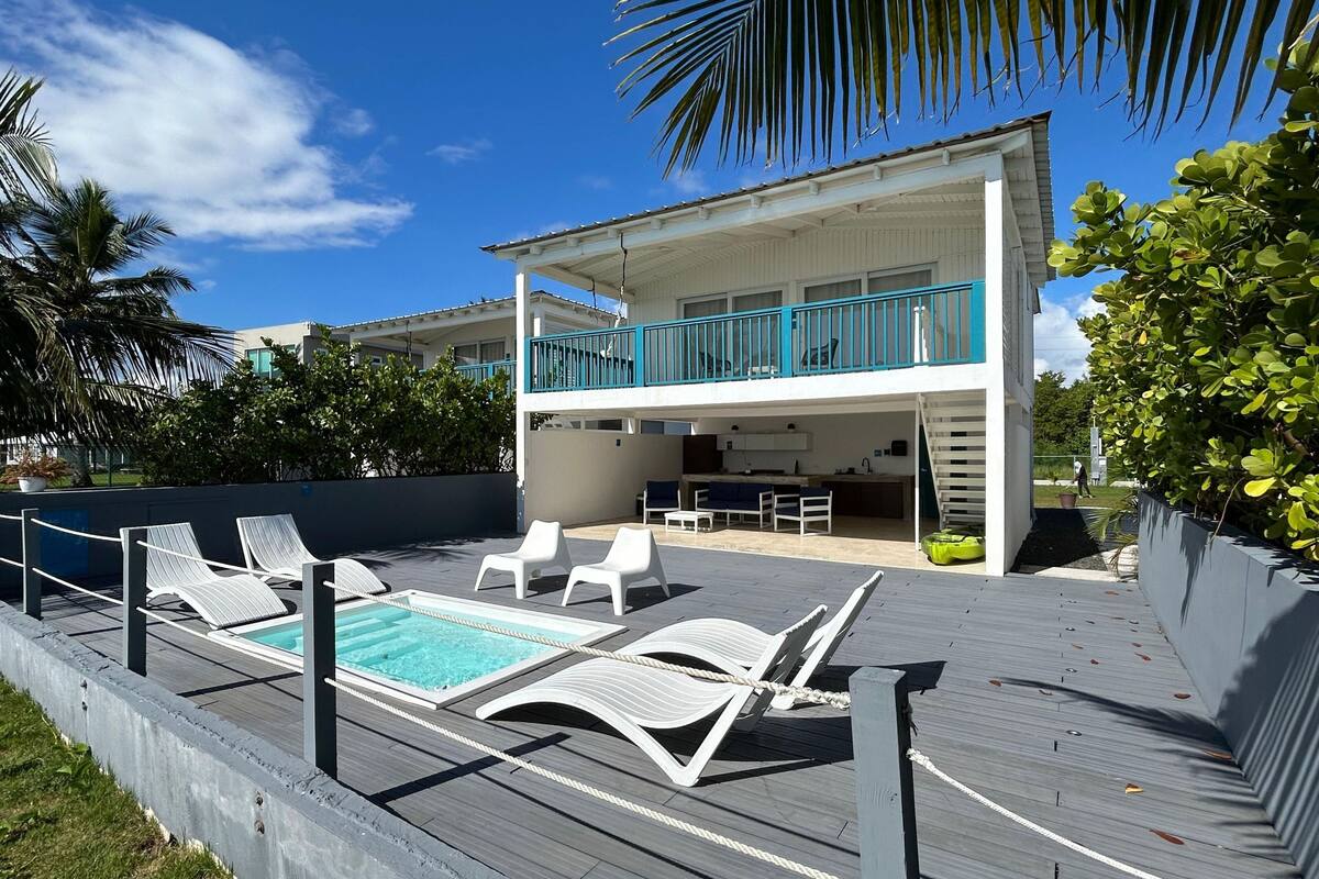 A two-story building with a pool area, outdoor seating, and a balcony.