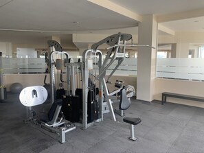 A gym with a variety of exercise machines, including a leg press and a chest press.
