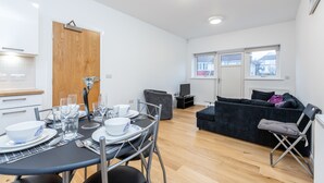 Un salon moderne comprenant un coin repas, un canapé et un téléviseur.
