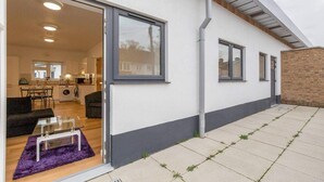 Une maison moderne dotée d’une cuisine, d’un coin repas et d’un petit patio.