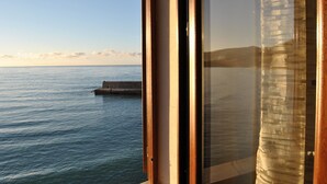 A view of the sea through a window with a wooden frame and a curtain. - Balcony Bellavista B - Holiday home by the sea (Cefalù)