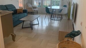 Ein geräumiges Wohnzimmer mit Sofa, Couchtisch und Essbereich.