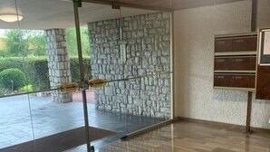 Ein modernes Interieur mit Holzboden, Glaswänden und einer Steinwand.