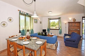 Un coin repas avec une table, des chaises et un canapé bleu.