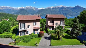 Un quartier résidentiel comprenant deux maisons, une allée pavée et un paysage montagneux en arrière-plan.