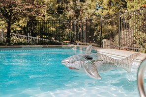 Une piscine avec un flotteur en forme de requin.