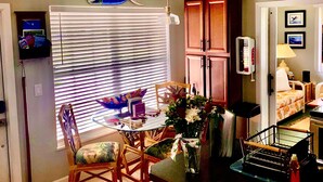 Un espacio habitable compacto con comedor, cocina y una pequeña zona de estar.