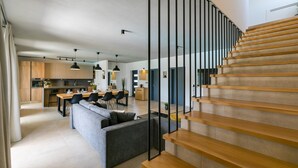 Et moderne interiør med trappe, køkken og spiseplads.