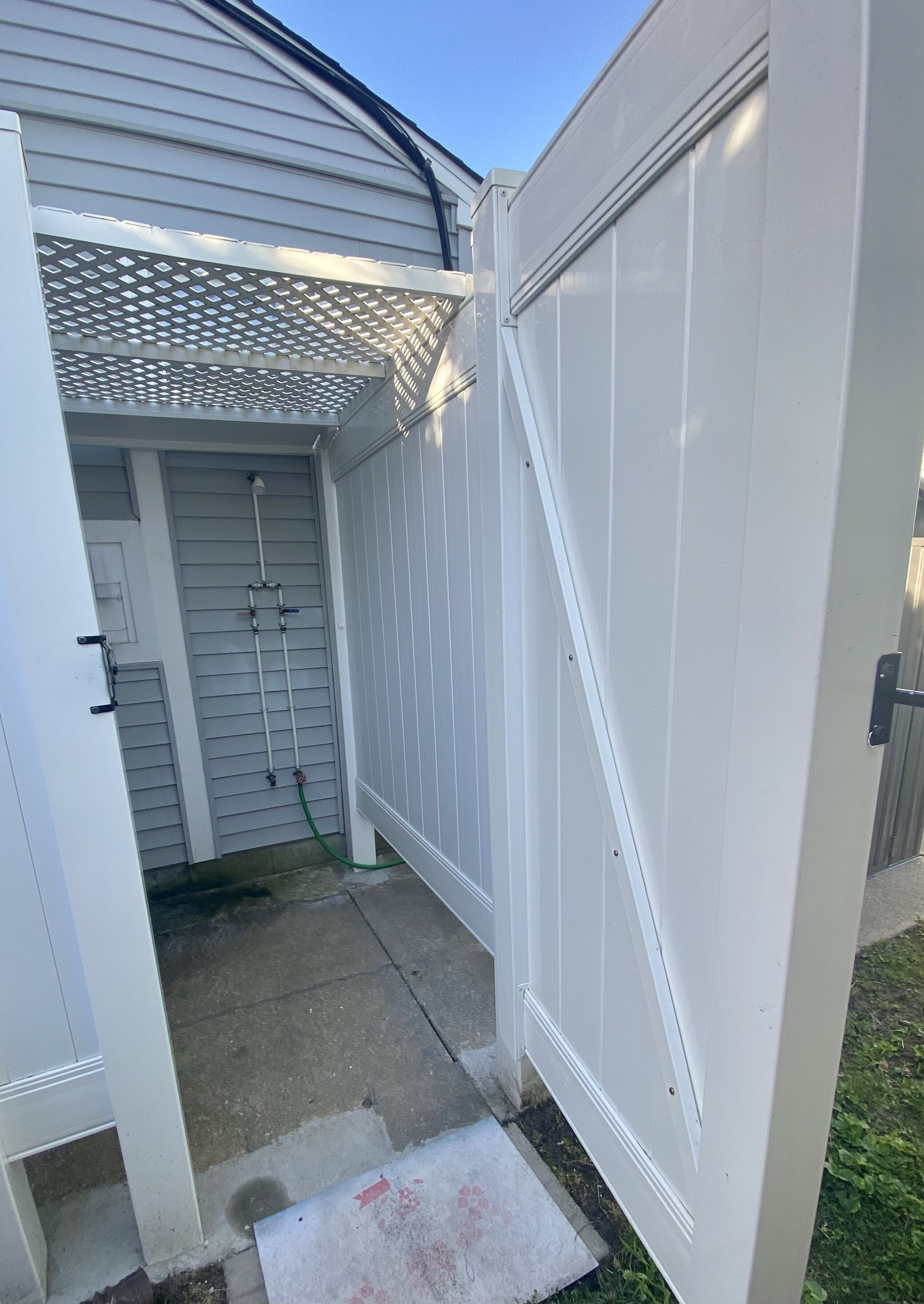 Eine weiße Garage mit einer Metalttür, einem Betonboden und einer kleinen Stufe zum Garageneingang.
