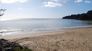 A beach with clear skies, calm water, and a rocky shoreline. - Villa (ST NAZAIRE)