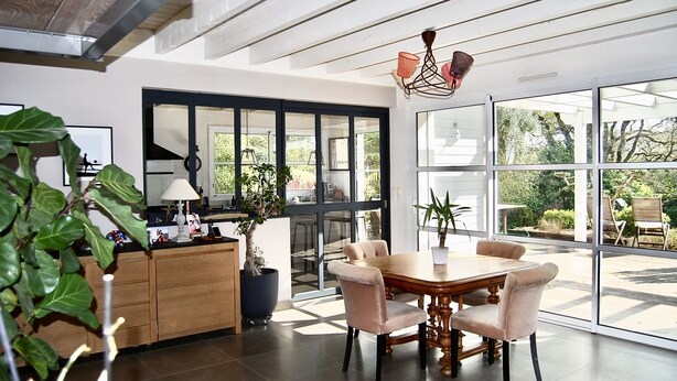 A modern kitchen with a dining area, large windows, and a view of the outdoors. - Villa (ST NAZAIRE)