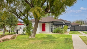 A residential house with a red door, a covered porch, and a well-maintained lawn. - ❤️of PHX in Historic Willo • Heated Pool • Chef's Kitchen • Fast WiFi (Phoenix)