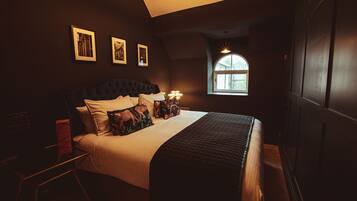 A bedroom with a large bed, a desk, and a window with a view.